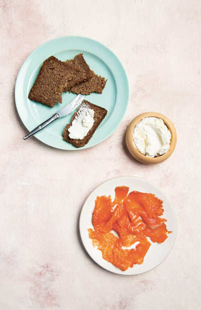 Pastrami and lox sandwich with fresh ingredients on a rustic wooden board