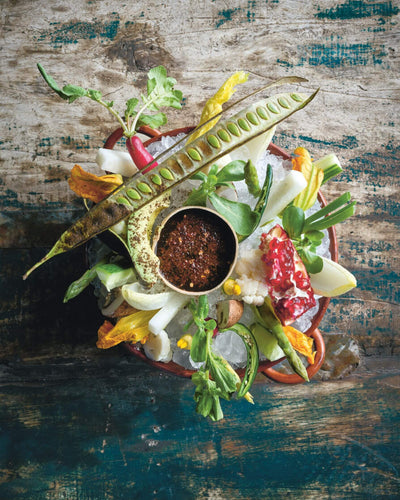 Capri crudities fresh vegetable platter with colorful sliced peppers carrots and celery on a white plate