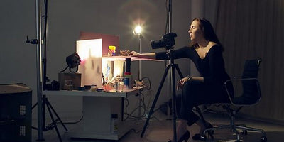 Close-up of Laurie Simmons artwork featuring a dollhouse interior with miniature furniture and figures in soft lighting