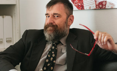 Bill Arning at NADA Miami Beach art fair holding artwork in gallery space