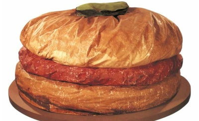 large abstract outdoor sculpture with geometric shapes against a blue sky background