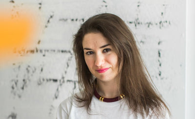 Megan Green collector interview portrait holding artwork in gallery setting