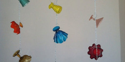 abstract sculpture by Tony Feher with colorful glass bottles arranged on a white surface