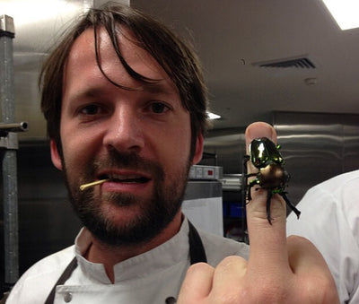 redzepi lead chef portrait in professional kitchen holding fresh ingredients