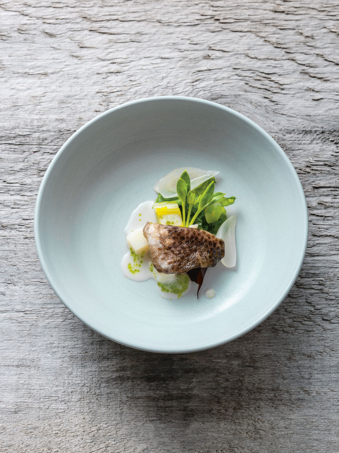 Poached Cod Cheek, Mussel Broth, Potato and Shore Greens. Photography: John Cullen 