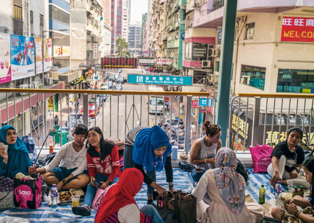 Hong Kong. As cities become denser, more complex and more contested, open space between buildings takes on special social significance. On Sundays, foreign domestic workers in Hong Kong congregate on sky-bridges and walkways to socialize outside the confines of their employers’ homes, celebrating their cultural identity as ‘interlocal’ citizens