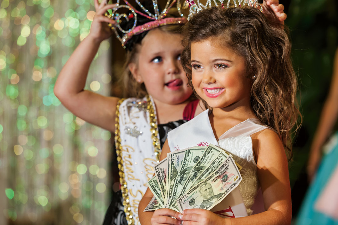 Kailia Deliz, 5, receiving her cash award for winning the Ventura County “Summer Fun” Beauty Pageant, Oxnard, California, 2011. The following year Kailia won $10,000 at the Universal Royalty National Pageant, a competition that is featured on the TV show Toddlers and Tiaras. From Generation Wealth by Lauren Greenfield