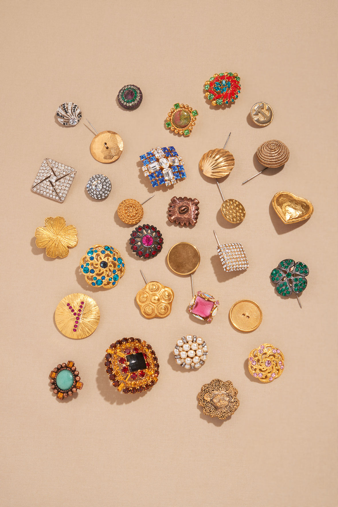 A selection of silvered and gilt metal, coloured diamanté and glass paste buttons from the trays of buttons in Yves Saint Laurent’s studio
