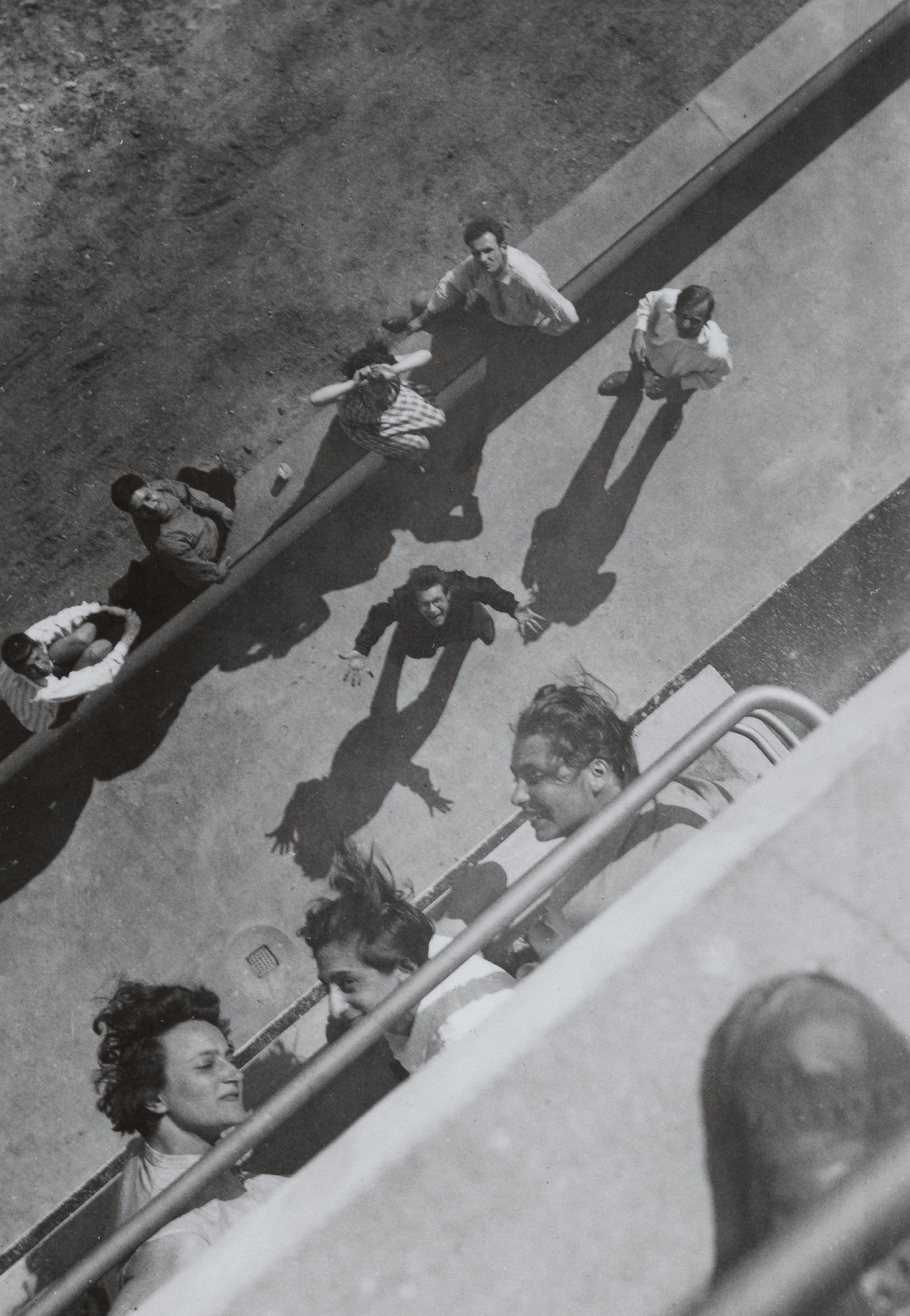 View from the Prellerhaus balcony, including Anni Albers (top center) with Ursula Schneider, Grete Reichardt, Gunta Stölzl, Max Bill, Bruno Streiff, Shlomoh Ben-David (Georg Gross), and Gerda Marx, 1927. Bauhaus, Dessau. 