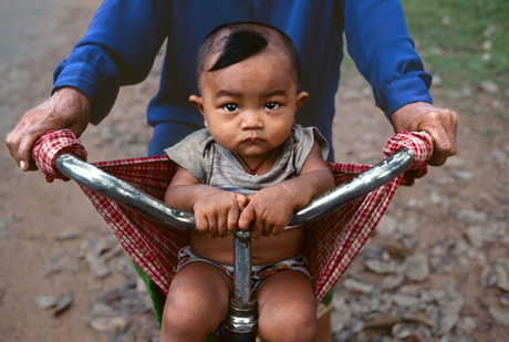 Steve McCurry, Baby in a bicycle sling at Banteay Srei, Angkor, Cambodia (2000)