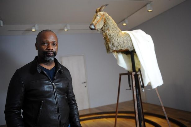 Theaster Gates beside his work, A Complicated Relationship between Heaven and Earth, or When We Believe