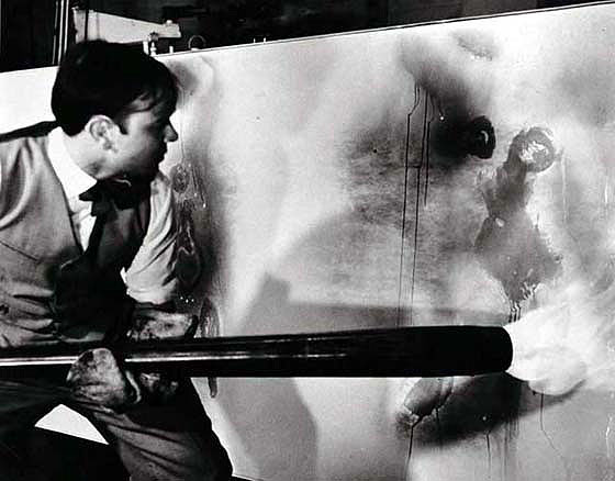 Yves Klein creating one of his fire action paintings, 1961