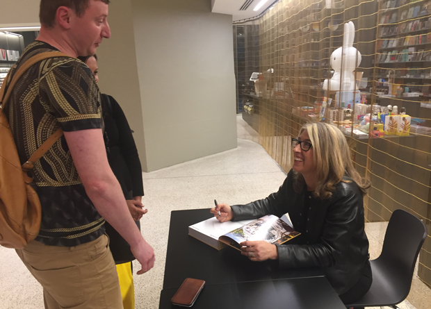 Lauren Greenfield signs a copy of Generation Wealth for a fan after her talk