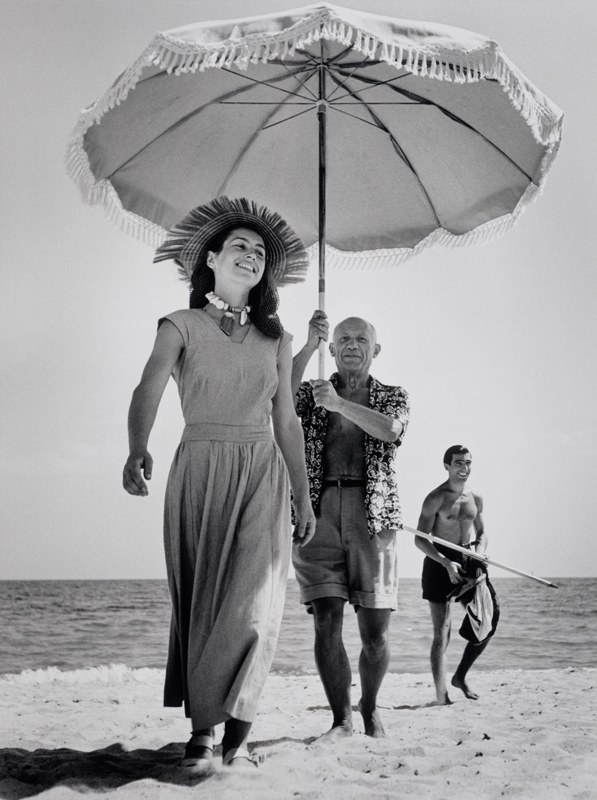 Pablo Picasso with his nephew Javier Vilato and Françoise Gilot on the beach. Golfe-Juan, France. August, 1948 © Robert Capa © International Center of Photography / Magnum Photos