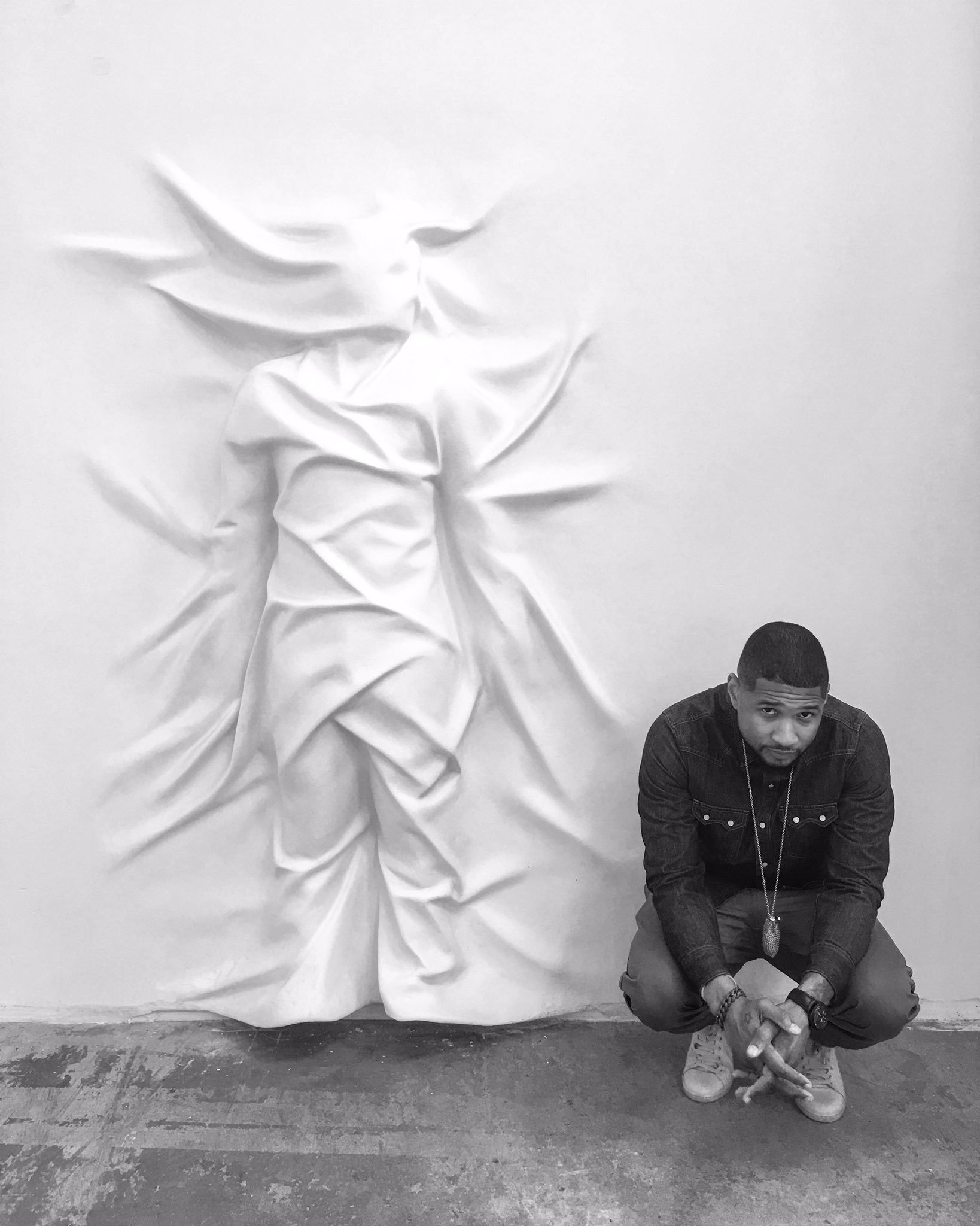 Usher beside a work by Snarkitecture's Daniel Arsham. Image courtesy of Arsham's Twitter