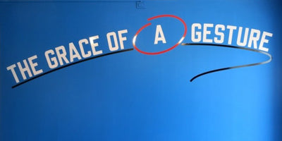 close-up of Lawrence Weiner artwork featuring bold text on a white background