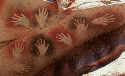 rock art painting on cave wall with human and animal figures in earthy tones