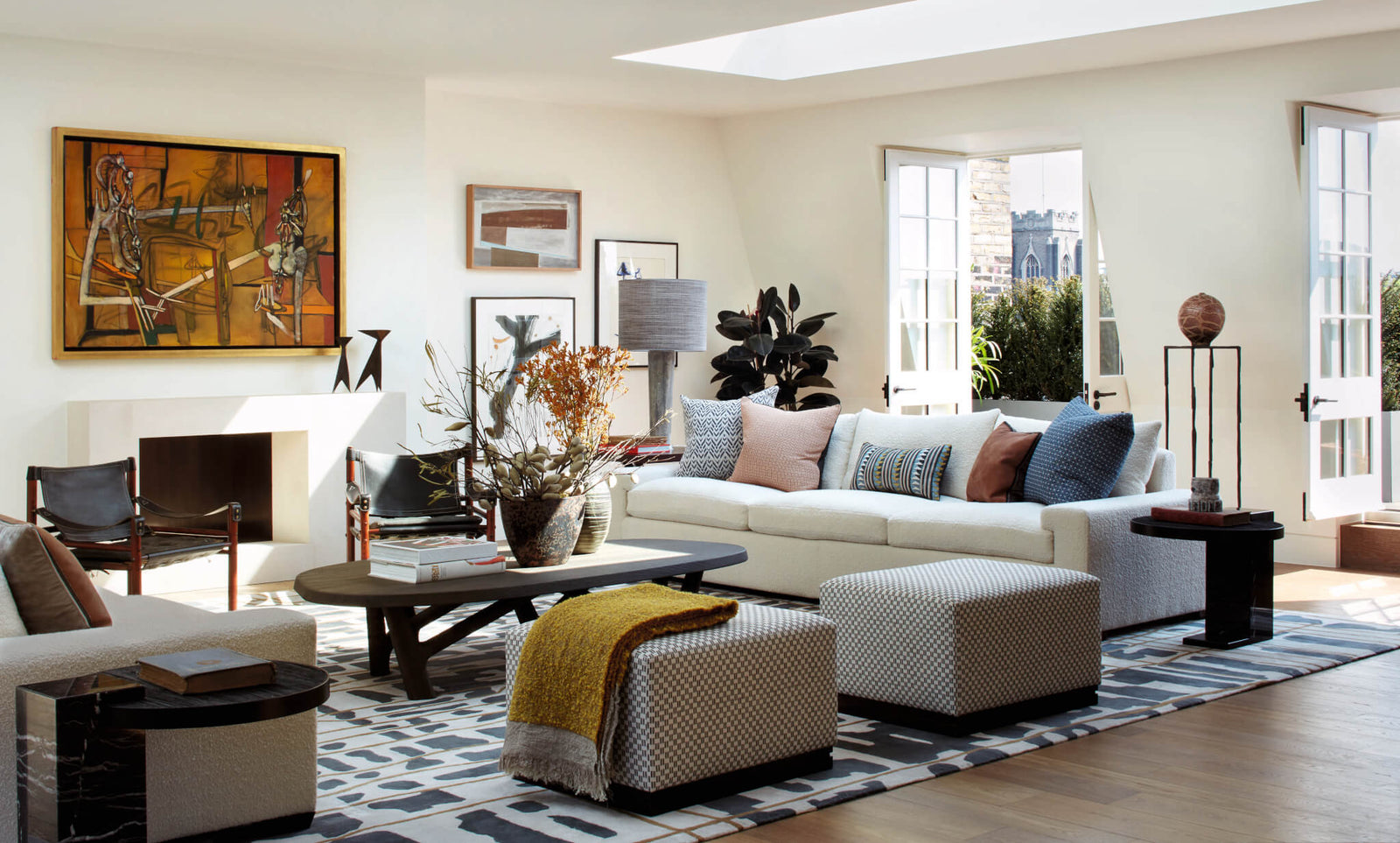 modern living room with white sectional sofa, decorative pillows, abstract artwork, wooden coffee table, and natural light from windows