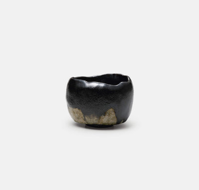 ceramic bowl with a textured black finish and a natural rocky base, designed for decorative or functional use
