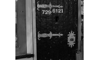 The story behind Jeff Wall's fortified door photograph showing a close-up of a sturdy, industrial-style door with metal reinforcements and textured surfaces