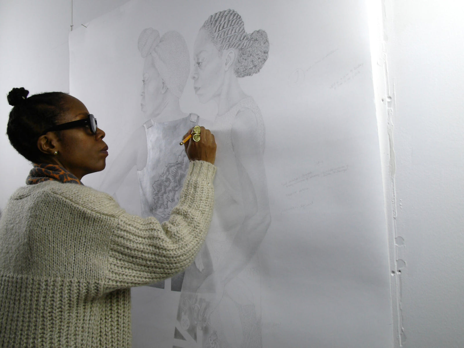 artist sketching on a large paper canvas detailed fashion illustration in a studio setting, wearing a cozy sweater and oversized sunglasses, vibrant hair styled with braids and a bun