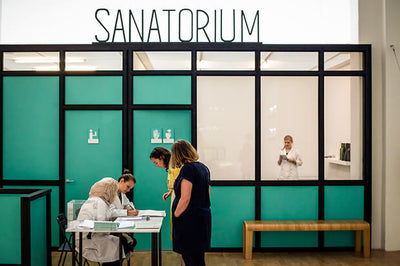 sanitorium building exterior with clear sky and surrounding trees