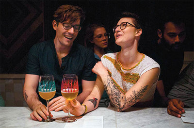 two beer glasses on a wooden table with frothy beer and sunlight background