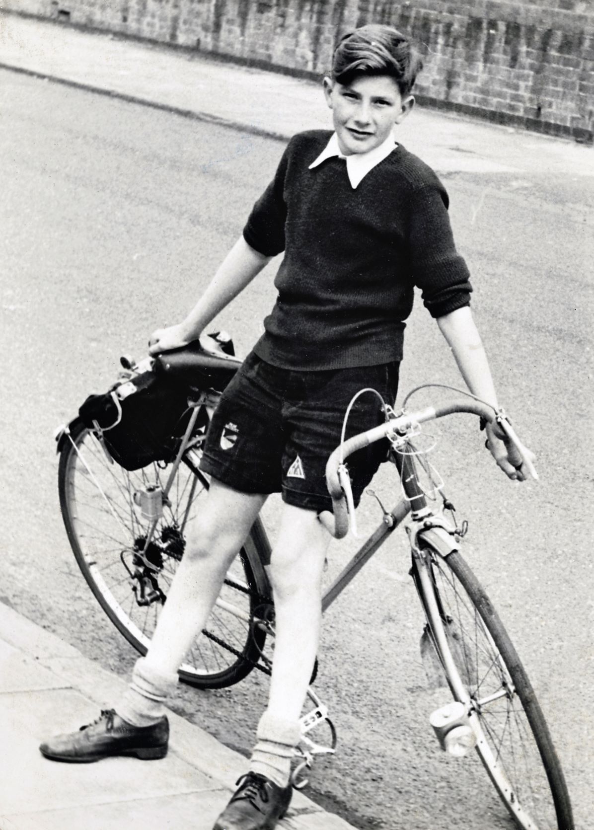 A uniform-clad Paul leans proudly on his blue Paramount bicycle