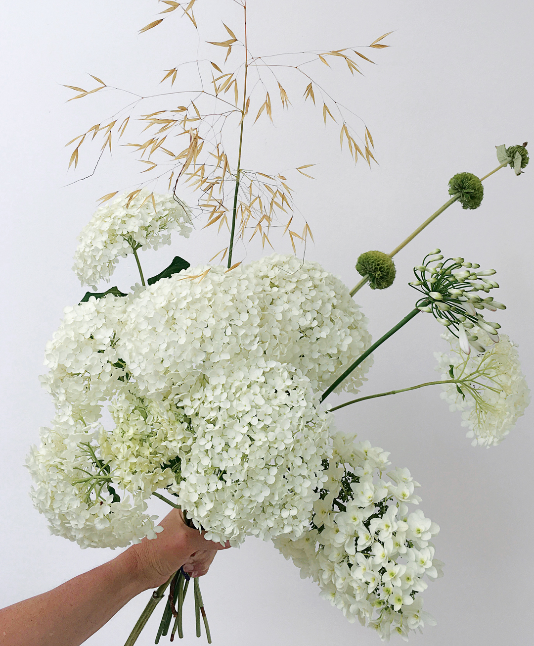 July bouquet using garden-picked flowers – smooth hydrangea, agapanthus, golden oats and phlomis seed heads - Bold Oxlip