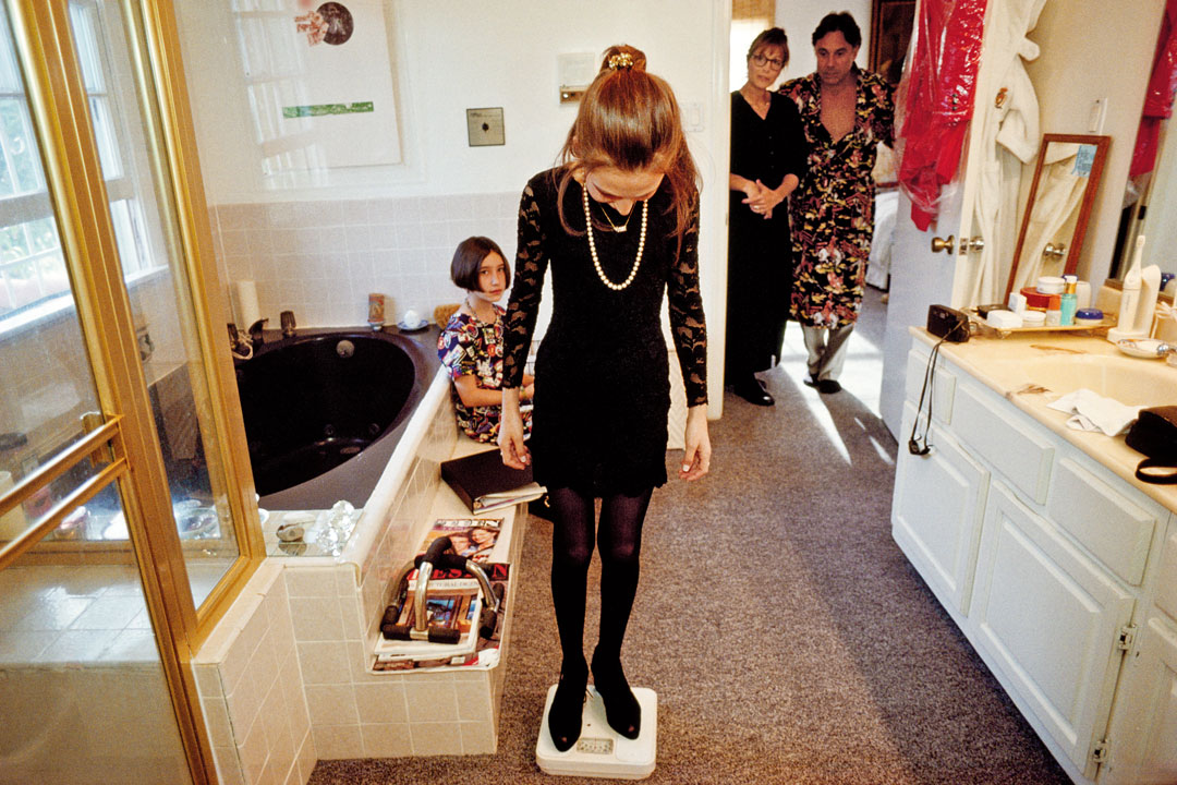 Ashleigh, 13, at home with her friend and parents on her bat mitzvah day, Santa Monica, 1993. Her mother says, “Ashleigh was the star of the day. She was kind of like a budding rose coming into her own and having it all her way.” From Generation Wealth by Lauren Greenfield