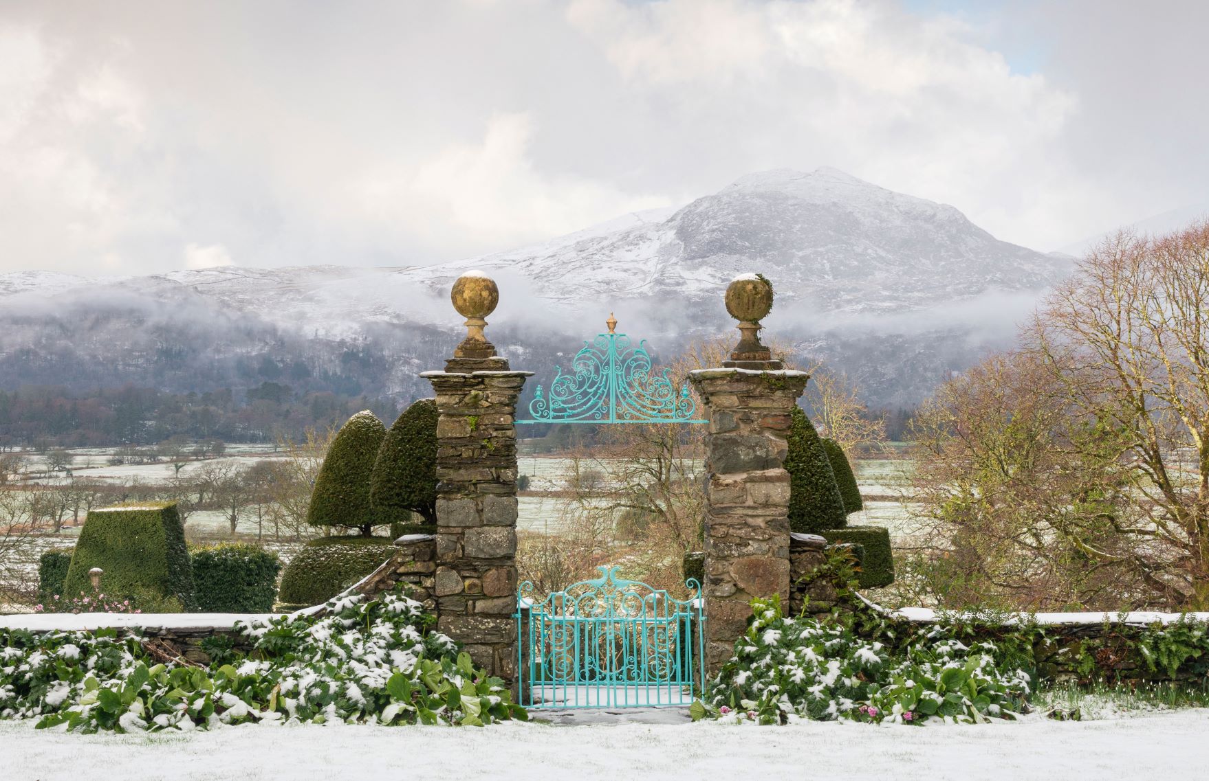 Borrowed Landscape. The garden at Plas Brondanw, Llanfrothen, Gwynedd, in Wales, UK, with a view of Snowdonia. Open to the Public. Picture credit: © Richard Bloom. A borrowed landscape is an element of a garden composition that lies beyond the physical garden confines but which is brought into focus as part of the overall visual experience.