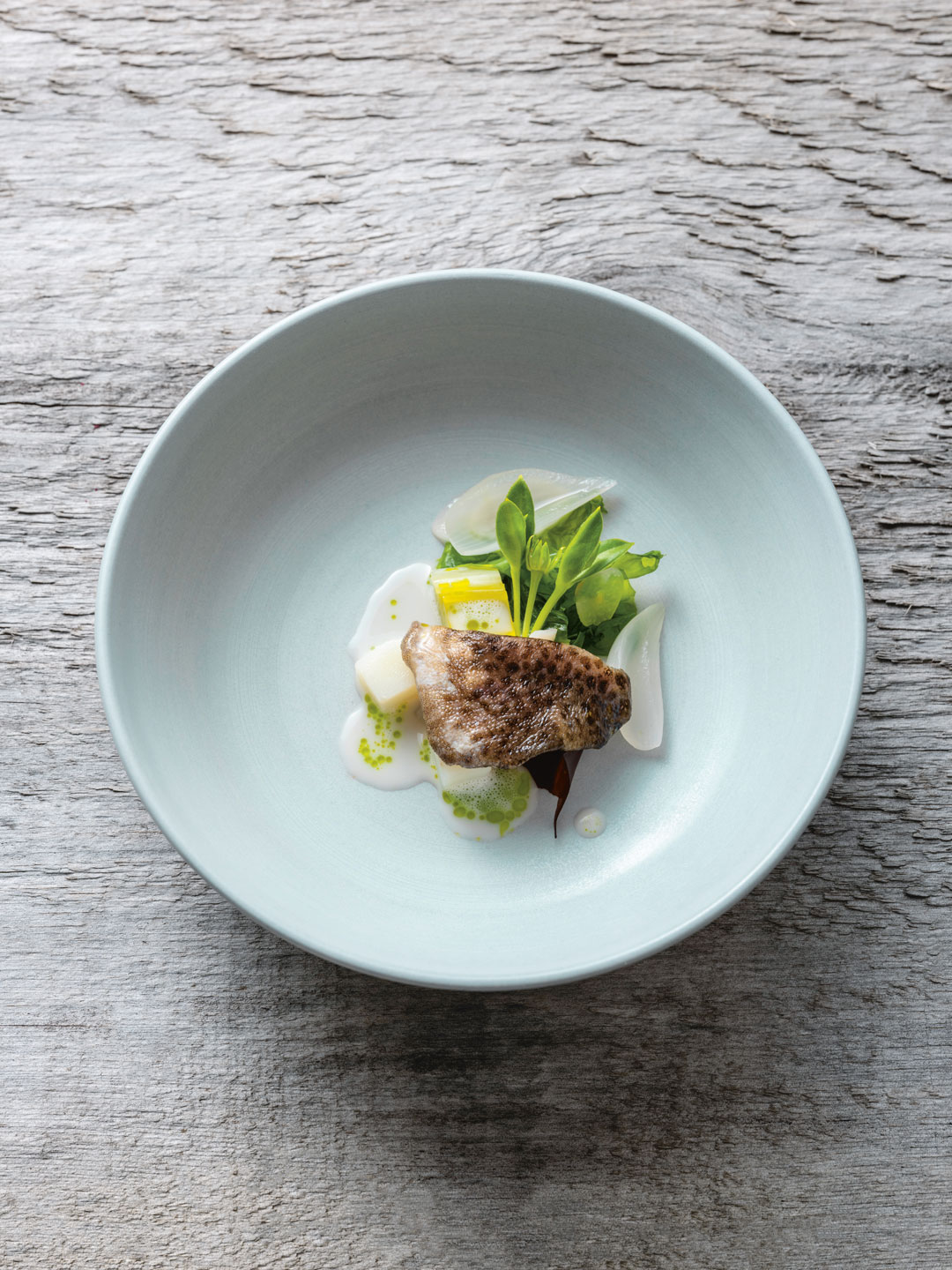 Poached Cod Cheek, Mussel Broth, Potato and Shore Greens. Photography: John Cullen