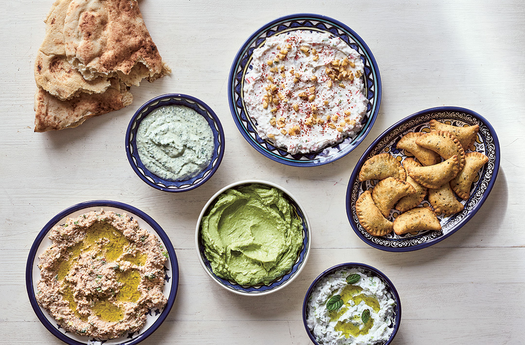 Dips and Small Bites: clockwise from left: Taboon Bread; Parsley or Cilantro (Coriander) Tahini Spread; Walnut and Garlic Labaneh; Deep-Fried Cheese and Za’atar Parcels; Garlic and Cucumber Labaneh; Avocado, Labaneh, and Preserved Lemon Spread; Labaneh And Bulgur Spread.