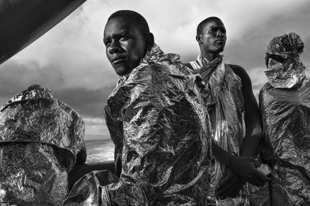 Francesco Zizola, Italy, 2015, Noor. Migrants wrapped in emergency blankets two days after being rescued catch sight of the Italian coast for the first time; Strait of Sicily, Mediterranean Sea, 23 August 2015.