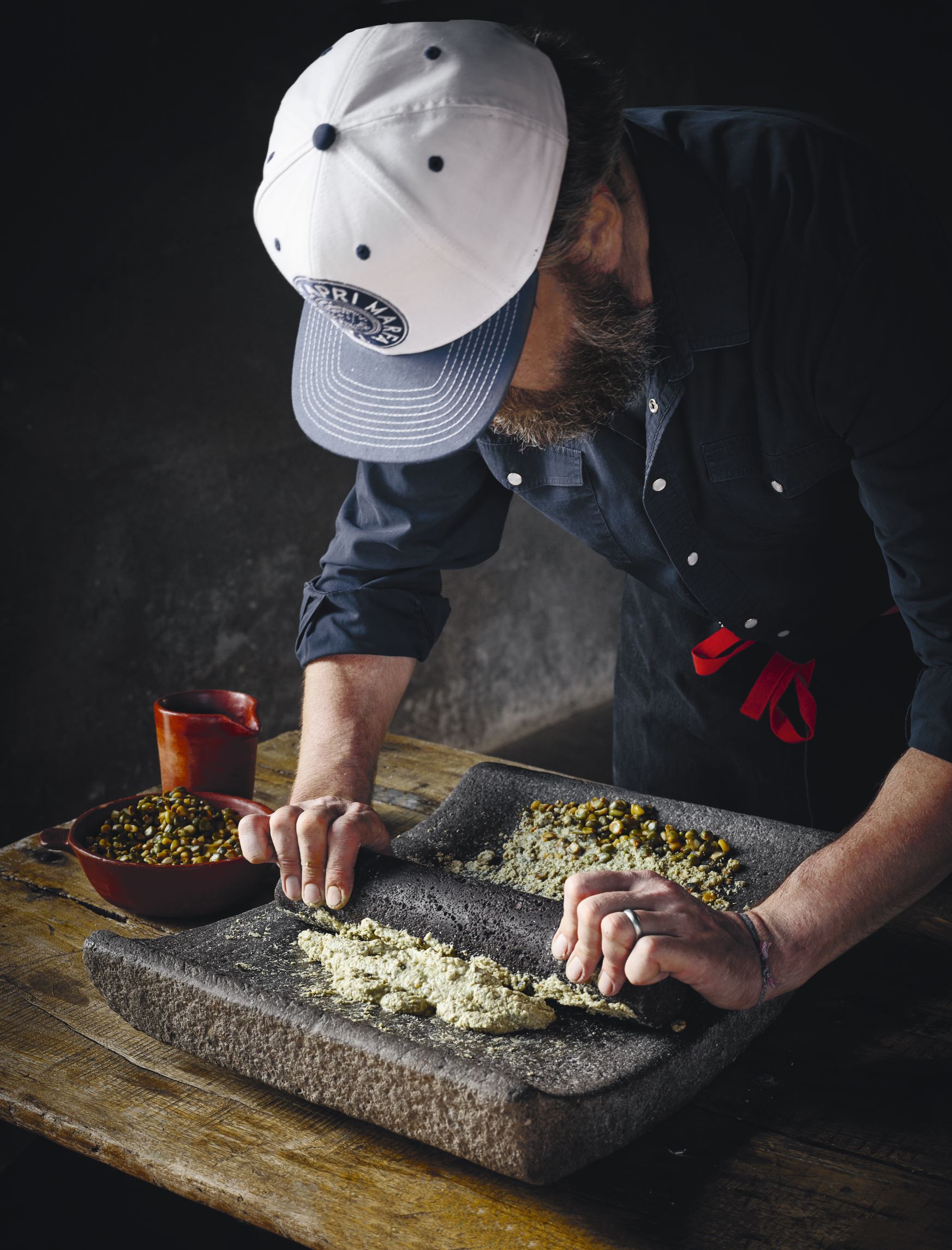 Rocky Barnette, chef at The Capri in Marfa, Texas, turns corn into masa using a traditional metate. As featured in Cooking In Marfa: Welcome, We've Been Expecting You