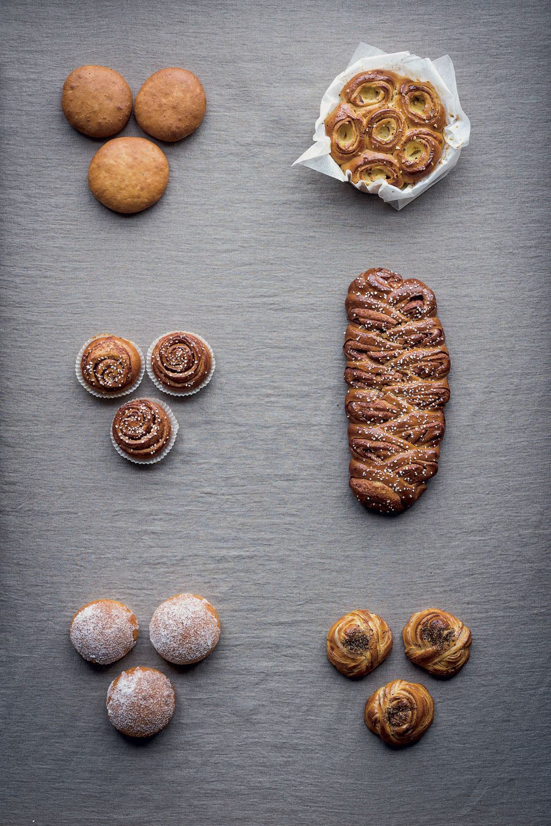Clockwise from top left: Plain Sweet Wheat Buns; Cinnamon Bun Cake; Cinnamon Bun Braid; Cardamom Bun Knots; Vanilla Cream Buns; and Cinnamon Buns