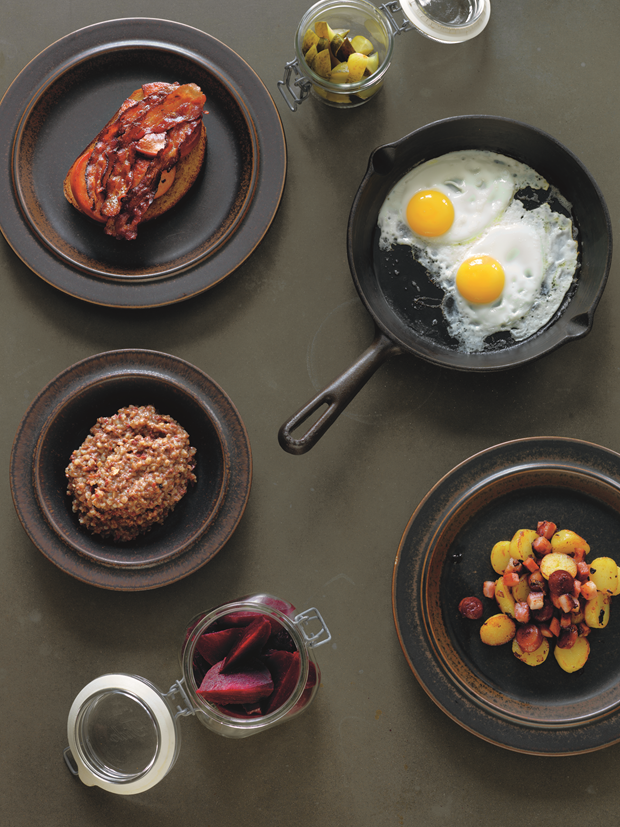 Clockwise from top left: Fried Salt Pork and Fried Falu Sausage on Plain White Loaf; quartered Brined Cucumbers; How to Fry a Really Good Egg; Nordic Hash; Pickled Beetroot; Mashed Pluck and Pearl Barley Hash. Photograph by Erik Olsson. From The Nordic Cookbook