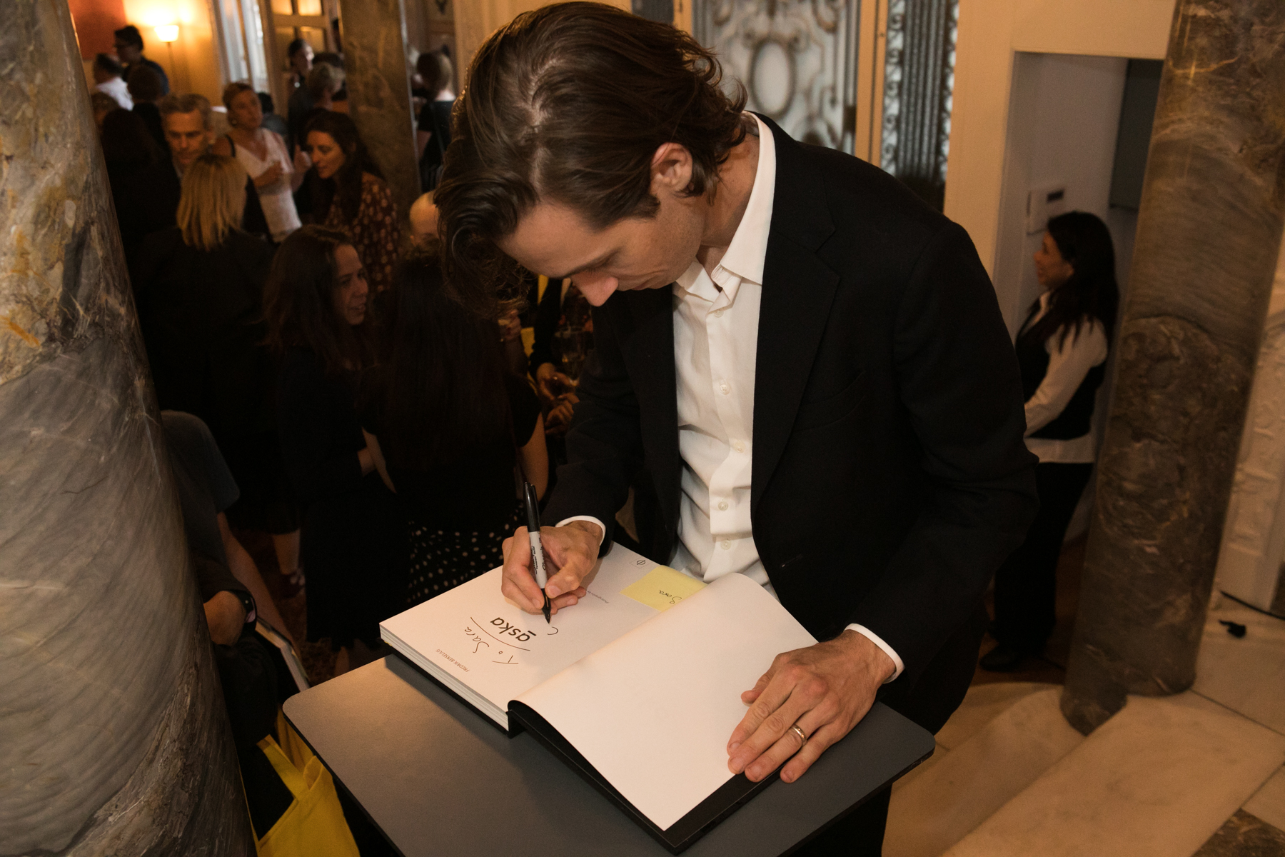 Fredrik signs a copy of his book at the Swedish residence - photo by Lauren Silberman/Consulate General of Sweden in New York