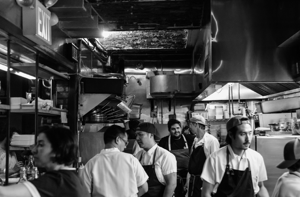 Jeremiah (third from left, back turned) and Fabián (back, centre) with their kitchen brigade. As reproduced in A Very Serious Cookbook