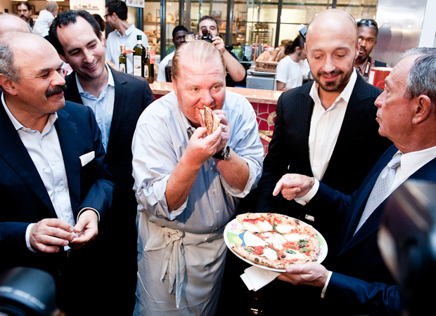 Oscar Farinetti (creator of Eataly) and Joe Bastianich (partner of Eataly) look on as Mario Batali takes and inaugural bite of rossopomodoro proffered by Mayor Michael Bloomburg at the opening of Eataly, New York