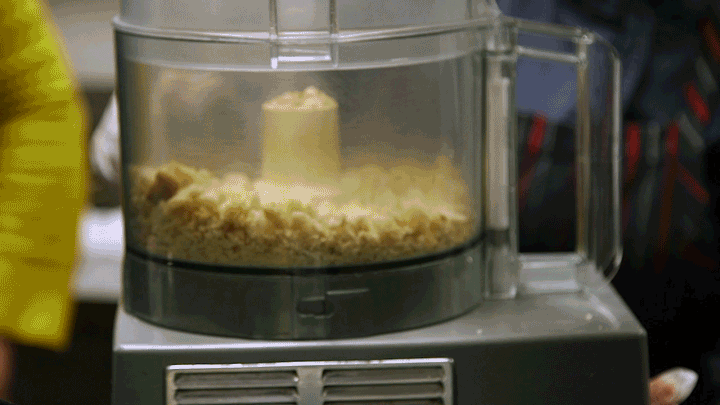 Massimo breaks old bread into breadcrumbs using a food mixer. Maia Stern/NPR