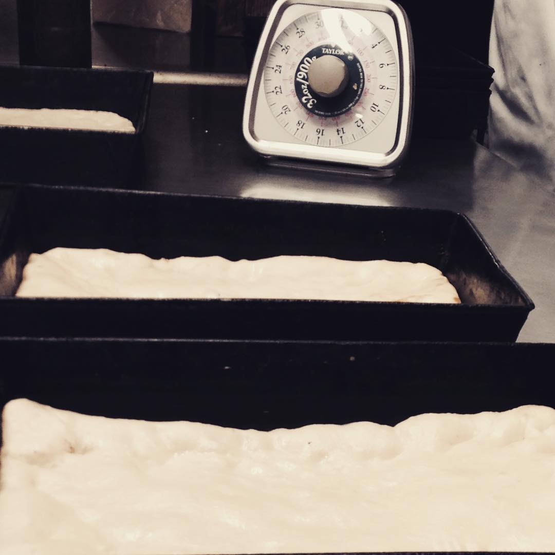 Detroit pizza bases proofing in signature baking trays at Buddy's, Detroit. Image courtesy of Buddy's Instagram