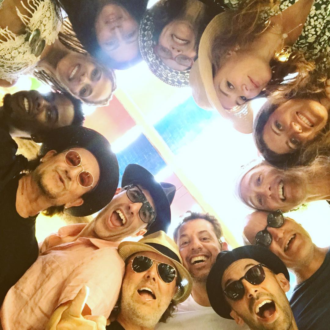 JR (bottom right) with Bono, Chris Rock, Ali Hewson, Isla Fisher, Matthew McConaughey, Guy Oseary, Woody Harrelson, Lars Ulrich, Sacha Baron Cohen, and Michelle Alves. Image courtesy of Guy Oseary's Instagram