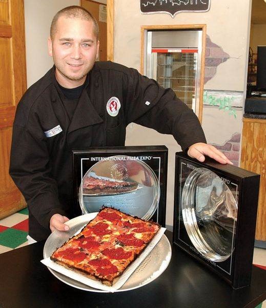 Shawn Randazzo with a Detroit-style pizza and his World Pizza Expo trophies
