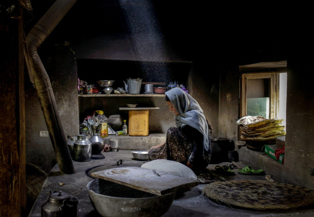 An Afghan woman bakes bread in her home. Afghanistan, Badakhshan, by Diana Markosian. Image courtesy of Magnum Photos