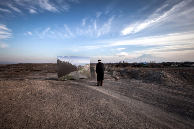 Genocide survivor Movses Haneshyan looking at a picture of his former home in Armenia, by Diana Markosian. Image courtesy of Magnum