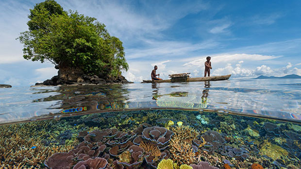 A traditional fisherman and his son in the waters of Kimbe Bay in Papua New Guinea - David Doubilet