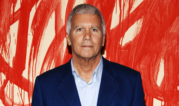 Larry Gagosian standing in front of a painting by Cy Twombly