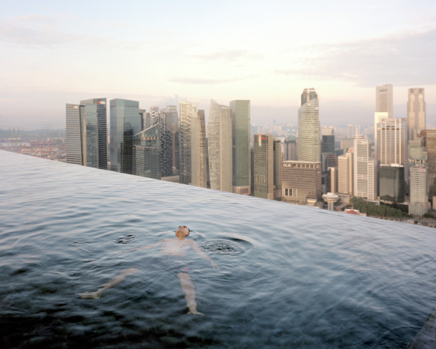 The swimming pool on the 57th floor at the Marina Bay Sands Hotel, Singapore; Singapore's financial quarter is in the background. From The Heavens, Annual Report by Paolo Woods and Gabriele Galimberti