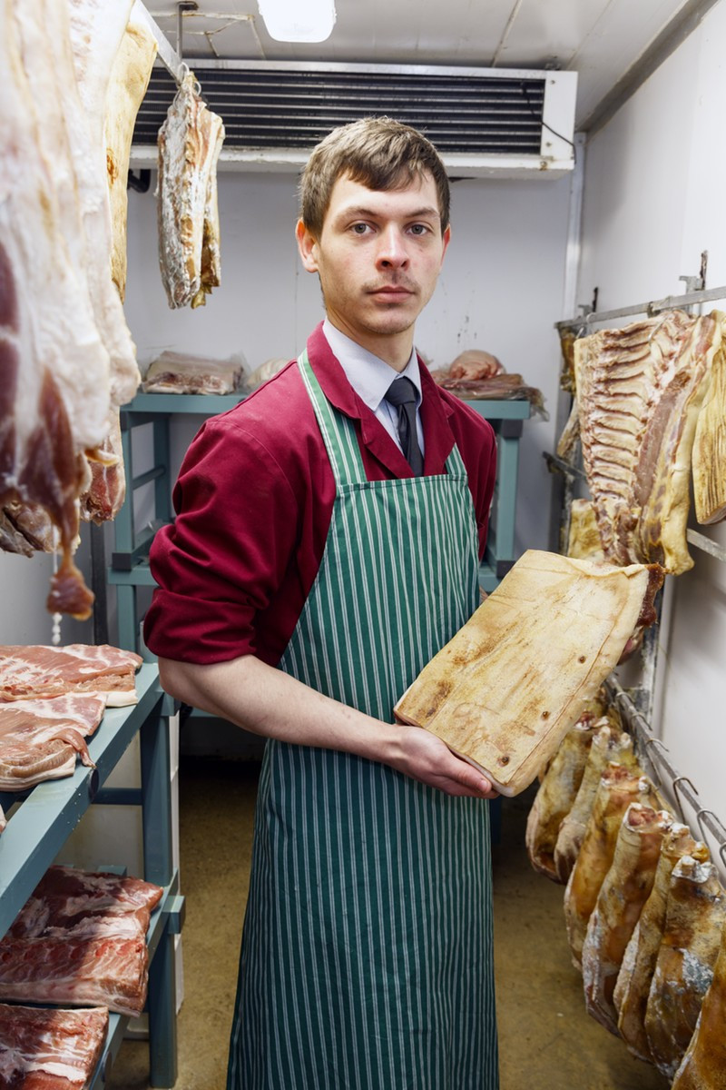 A Gloucestershire butcher holds a side of Gloucestershire Old Spot pork by Martin Parr. Martin Parr / Magnum